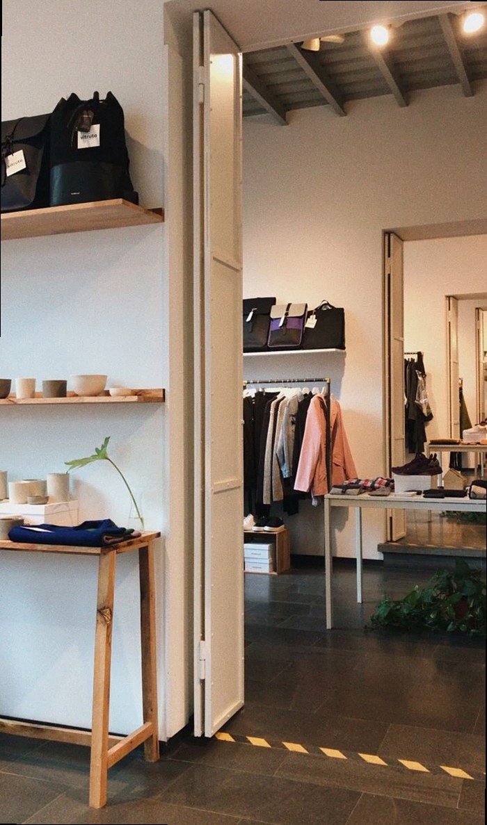 モダンなブティックの店内に、棚や衣類、アクセサリーが展示されている様子。